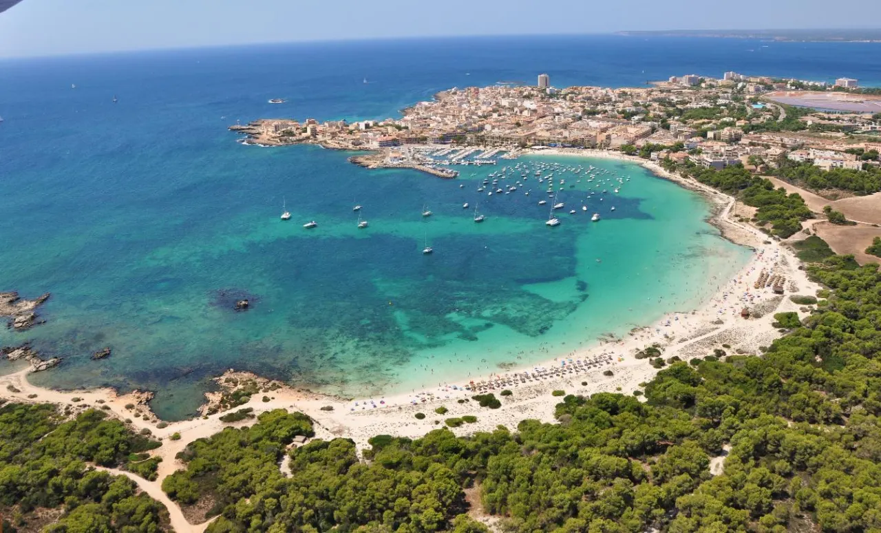 An aerial view of a sheltered cove and small harbour town on the south coast