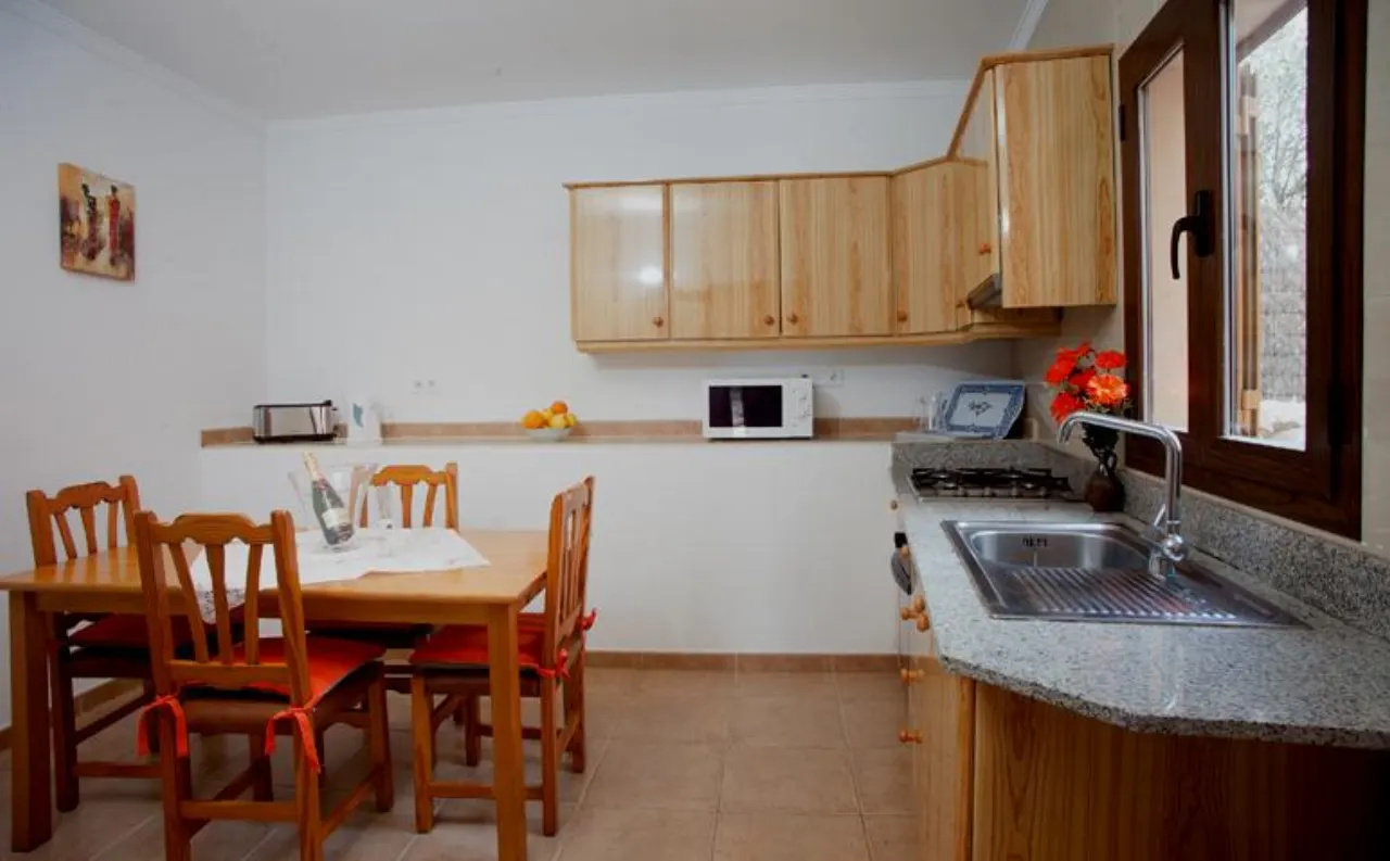 The kitchen at the finca, with wood cabinets and a wooden dining table