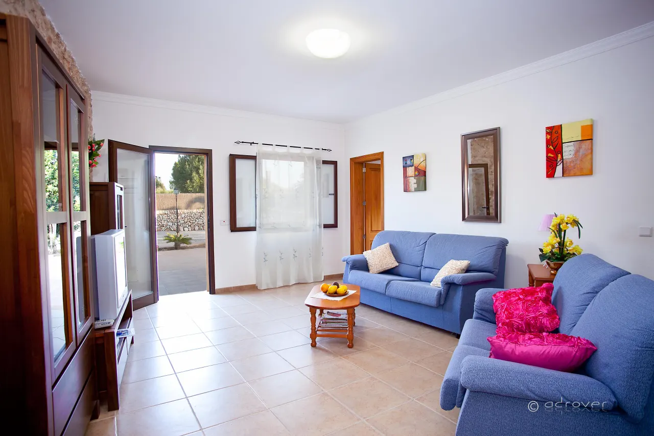 A second living area with blue sofas and a doorway out to the garden